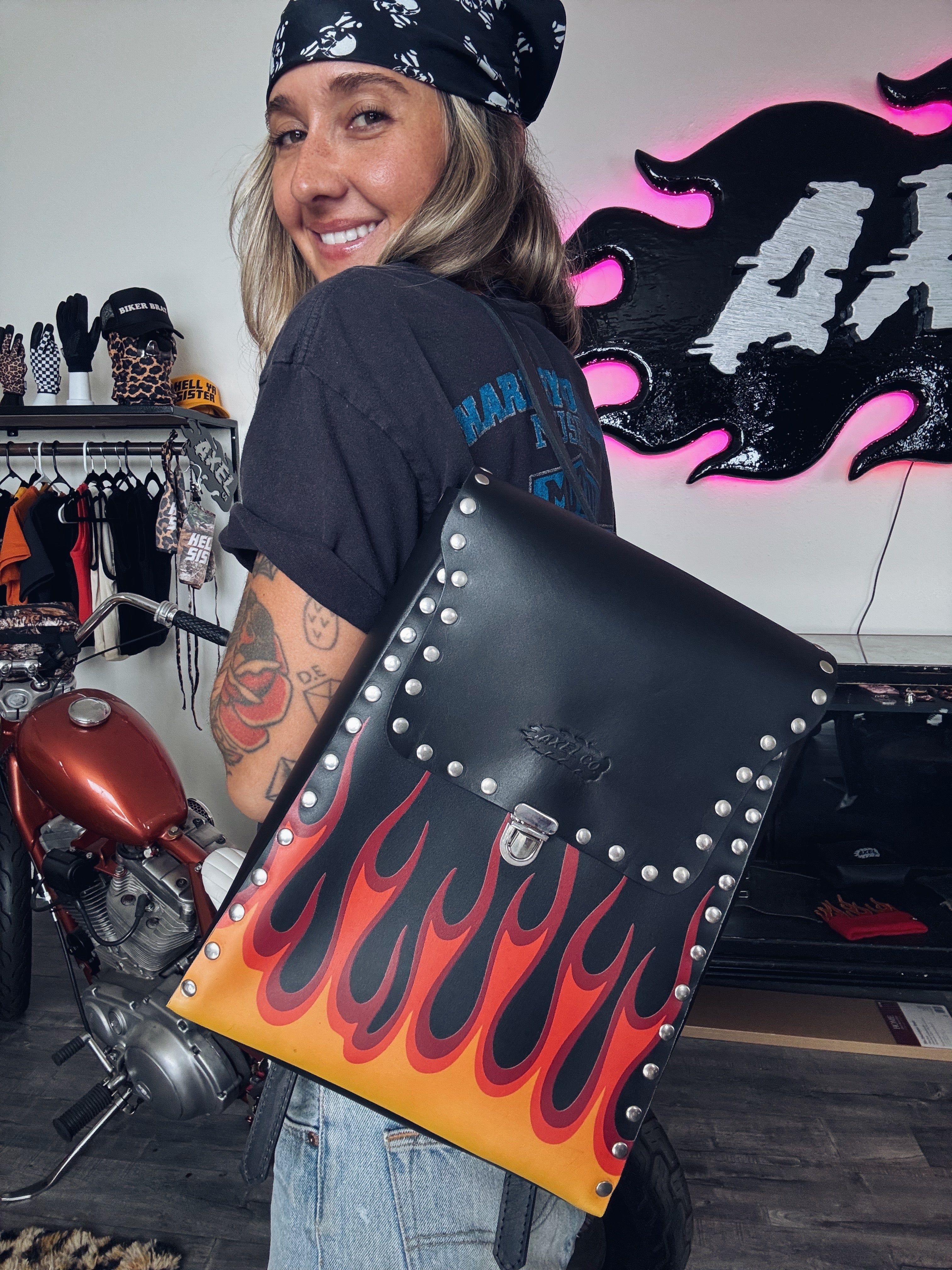 Becky Goebel holding her Axel Co backpack design with flames, studs and leather galore