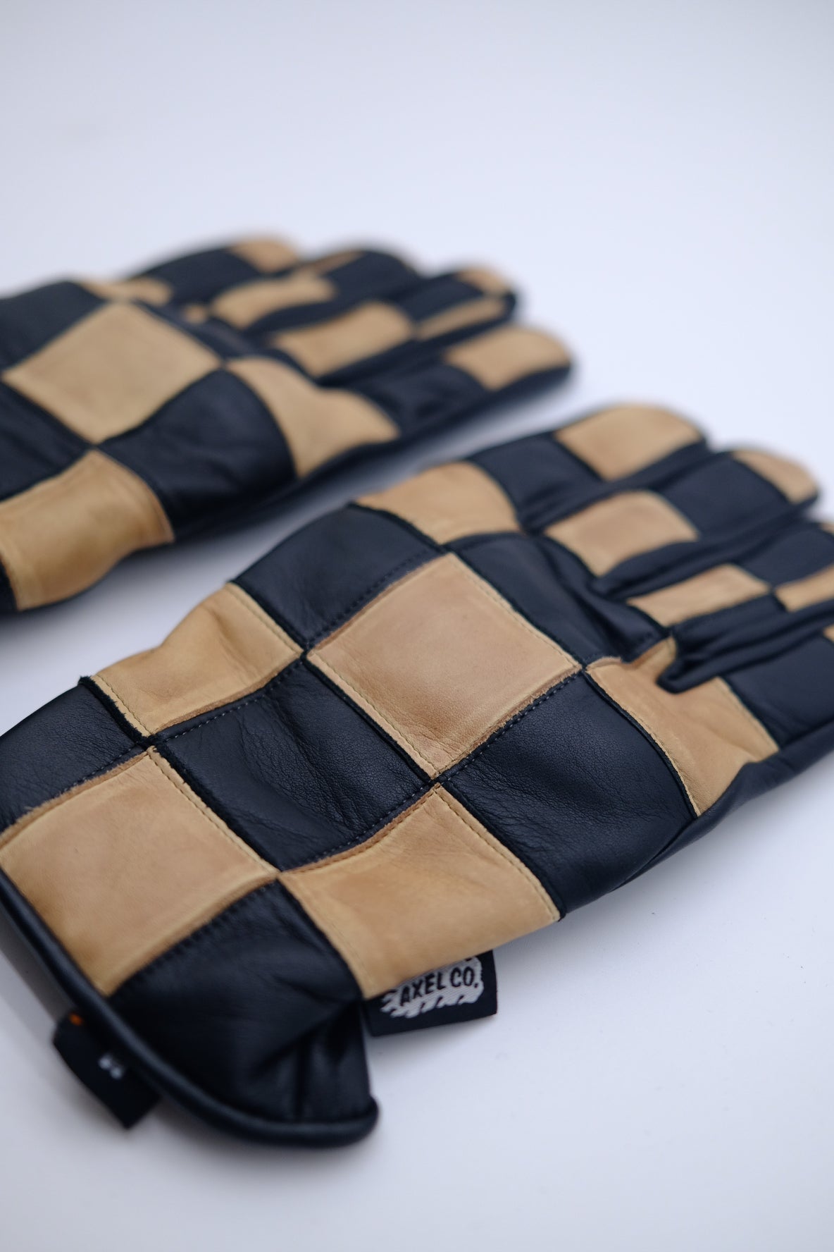 Pair of black and beige checkered motorcycle vintage gloves with custom tag
