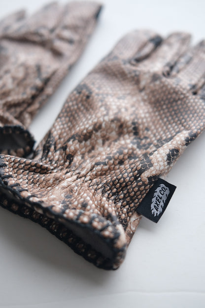 Snake skin patterned glove with a Axel Co tag on a white background