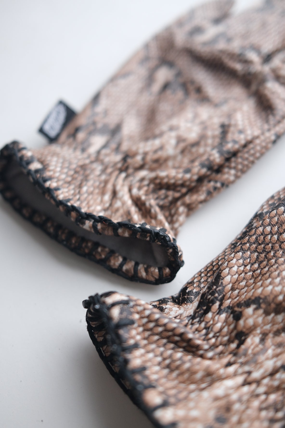 Pair of Motorcycle Gloves with snake skin pattern on a white background